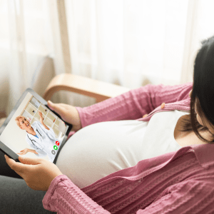 [Image: a pregnant person talking to a doctor on their tablet computer.]
